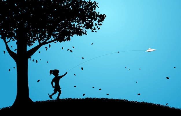 Silhouette of girl running to throw out origami paper airplane under big tree.