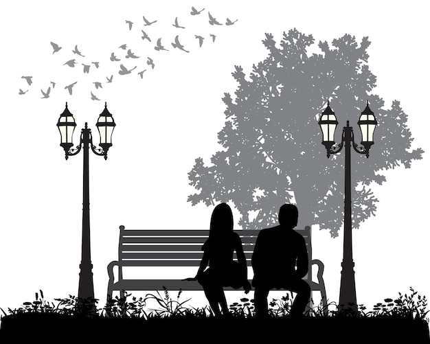 Silhouette of a guy and a girl sitting on a park bench