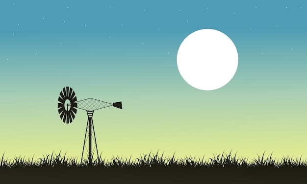 Silhouette of windmill and grass landscape