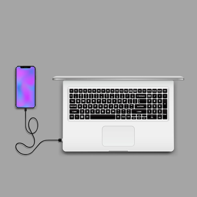 Smartphone with wireless charger connected to laptop top view