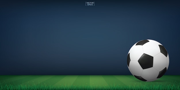 Soccer football ball on green grass of soccer field or football field stadium background