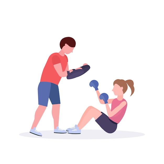 sportswoman boxer doing boxing exercises with personal trainer girl fighter in blue gloves working out on floor fight club healthy lifestyle concept  white background