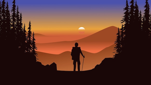 Sunset in foggy mountains with an explorer standing on the mountain