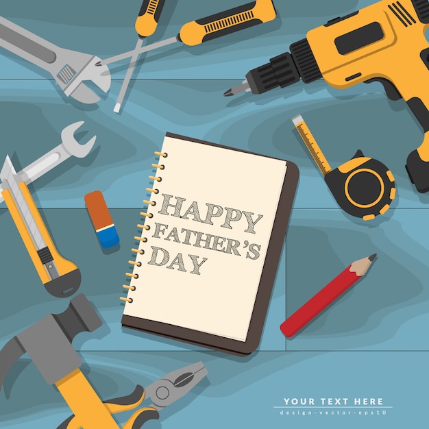 Text Happy Fathers Day writing in notebook lay on blue mechanic wooden desk with yellow home repair tools