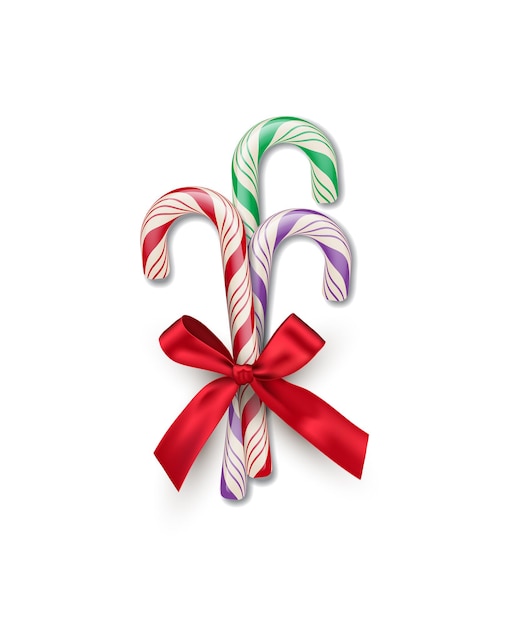 Three different color striped candy canes with red bow isolated on white background