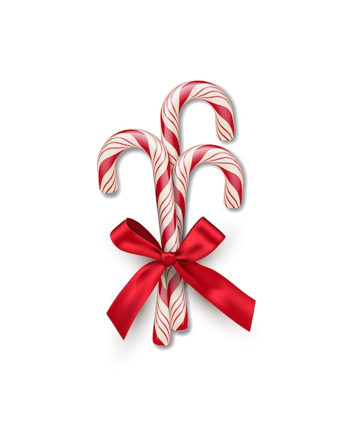 Three red striped candy canes with red bow isolated on white background