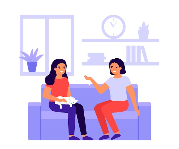 Two fun women friends talk at home on couch Happy girls with cat are meeting and conversation