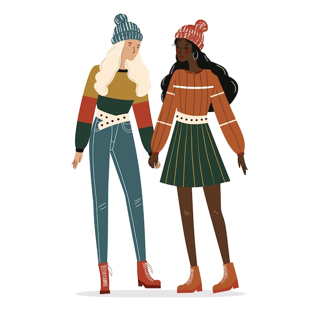 Two women holding hands one blonde one darkskinned wearing winter clothing Multicultural