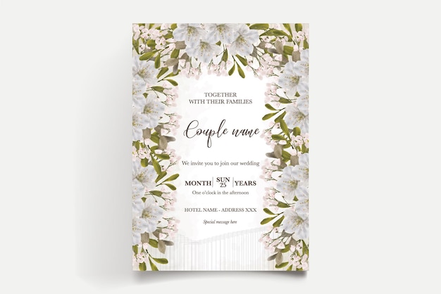 A wedding invitation with white flowers and greenery.