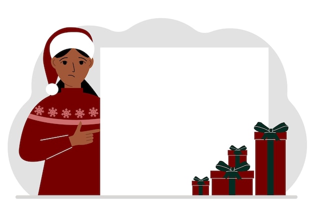 A woman in a Christmas or New Year's sweater with a red sana cap points his finger at a banner a blank poster or a large white sheet of paper with space for text