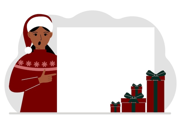 A woman in a Christmas or New Year's sweater with a red sana cap points his finger at a banner a blank poster or a large white sheet of paper with space for text