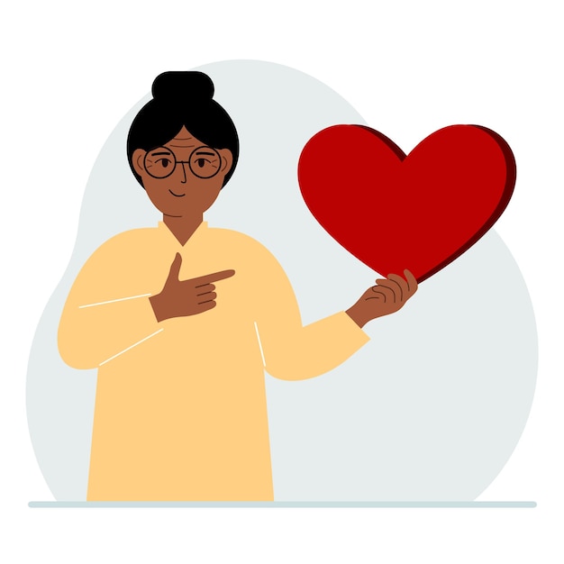 A woman holds a big red heart in his hand The concept of volunteering romantic relationship or love