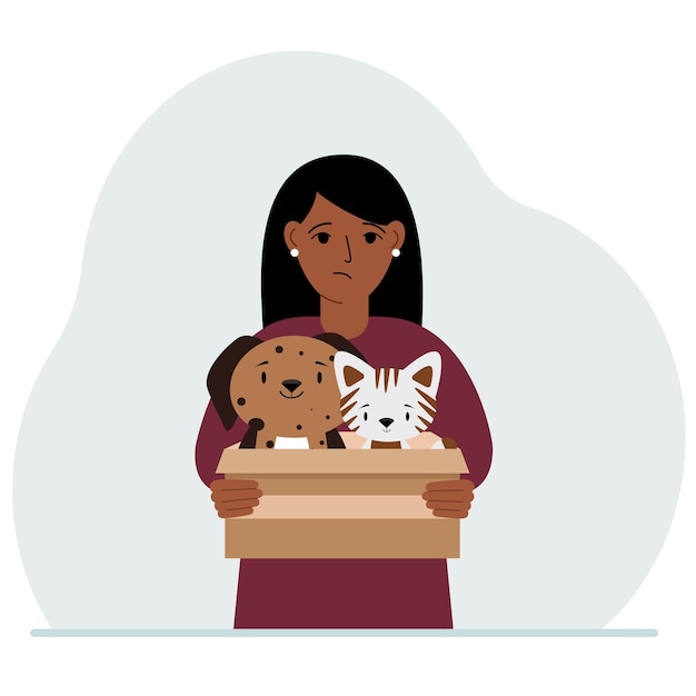 A woman holds a cardboard box with a cat and a dog The concept of rescue help and care for pets