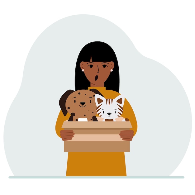 A woman holds a cardboard box with a cat and a dog The concept of rescue help and care for pets