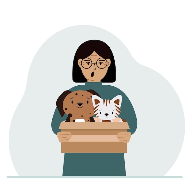 A woman holds a cardboard box with a cat and a dog The concept of rescue help and care for pets