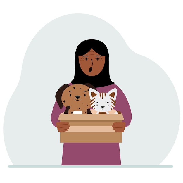 A woman holds a cardboard box with a cat and a dog The concept of rescue help and care for pets