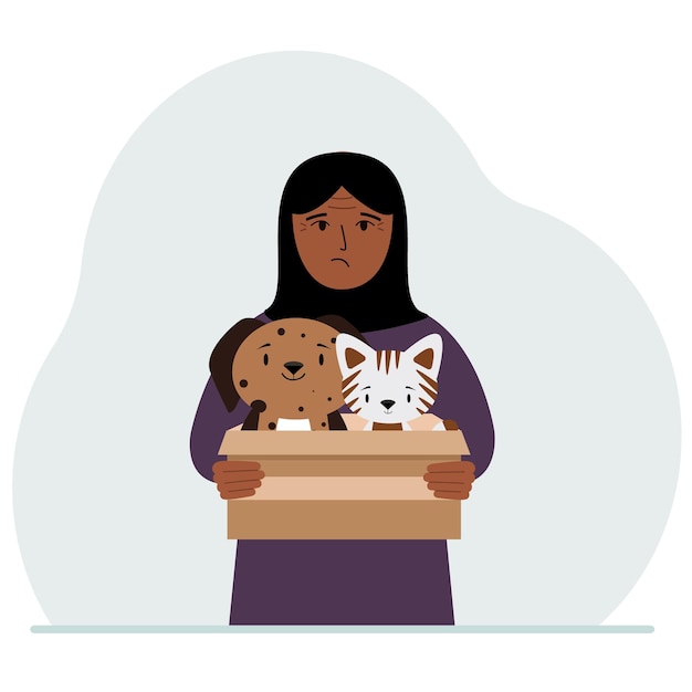 A woman holds a cardboard box with a cat and a dog The concept of rescue help and care for pets