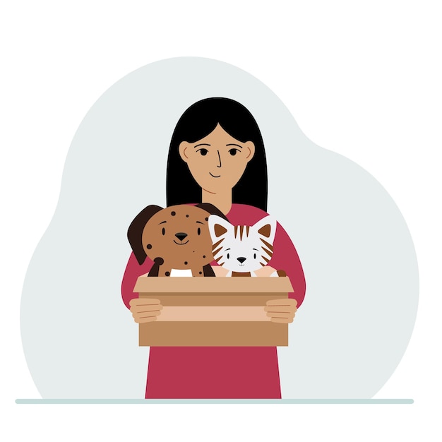 A woman holds a cardboard box with a cat and a dog The concept of rescue help and care for pets