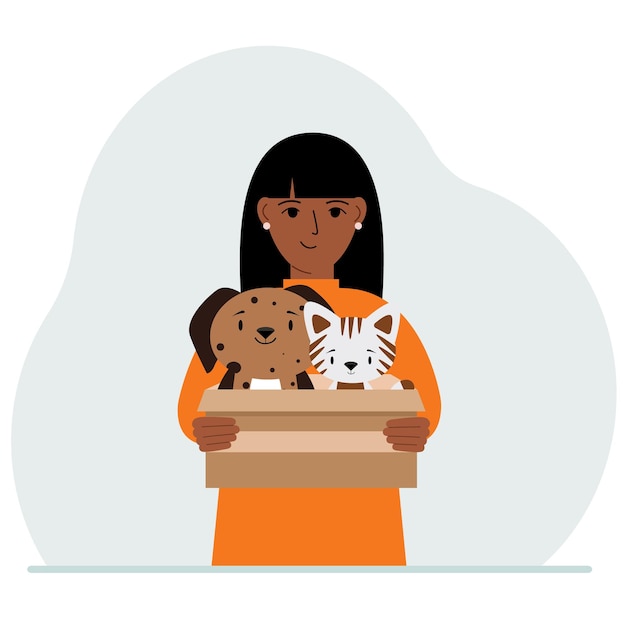 A woman holds a cardboard box with a cat and a dog The concept of rescue help and care for pets