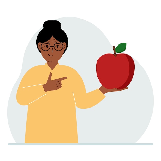 A woman holds a fresh and red apple in his hand Woman eats an apple Healthy food concept