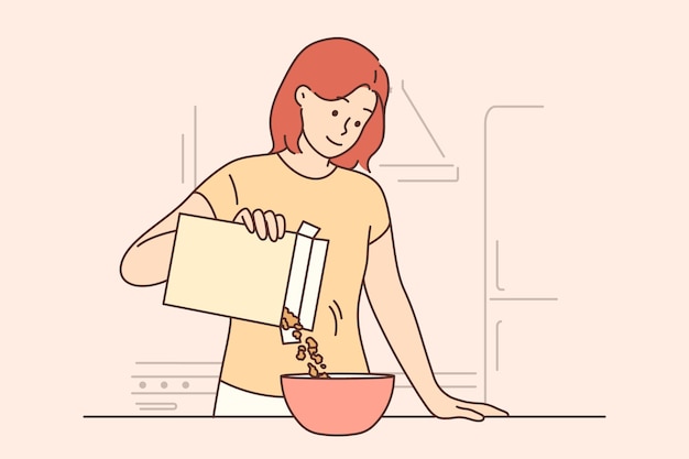 Woman is eating breakfast with cornflakes and holding box of muesli standing near kitchen table Girl prepares healthy breakfast to refresh herself before going to work or university