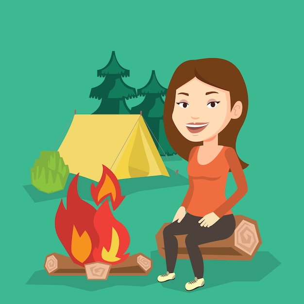 Woman sitting on log near campfire in the camping.