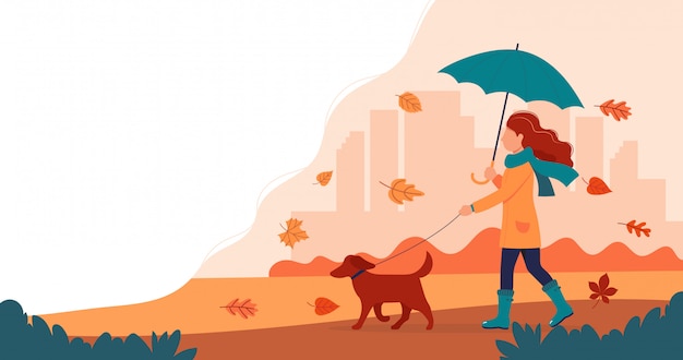 Woman walking a dog in autumn with umbrella. 