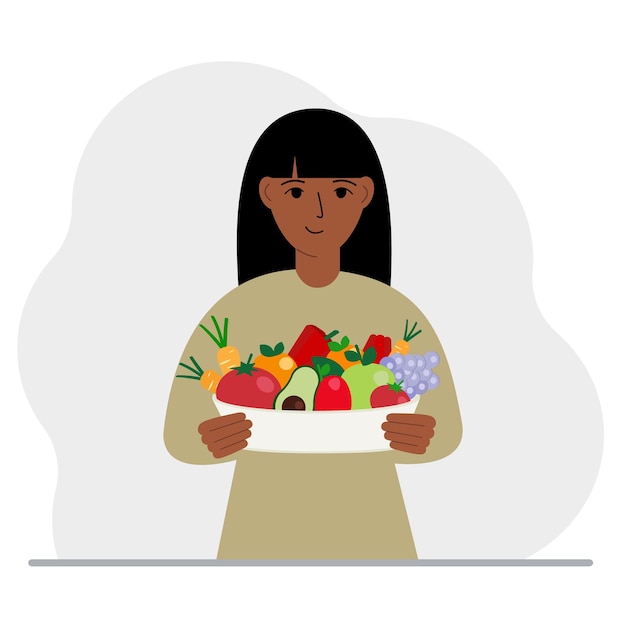 A woman with a large plate of healthy organic food vegetables and fruits The concept of healthy food healthy lifestyle vegetarianism agriculture