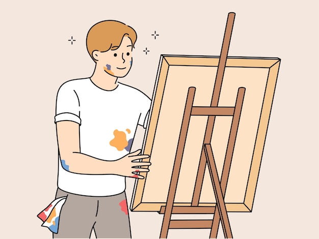 Young man drawing picture on easel