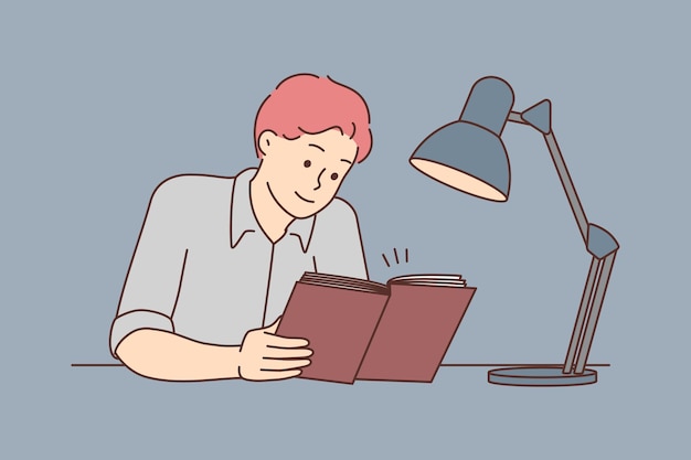 Young man sit at desk reading book