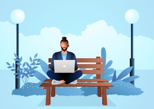 Young man sitting on wooden bench in the park while working with laptop