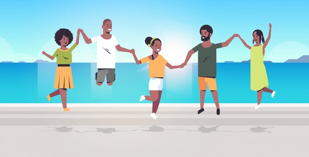 young people group jumping on beach men women holding hands summer vacation concept   friends having fun seaside sea ocean holiday travel full length horizontal